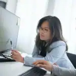 Young woman working on tax documents at home, gig economy tax planning.