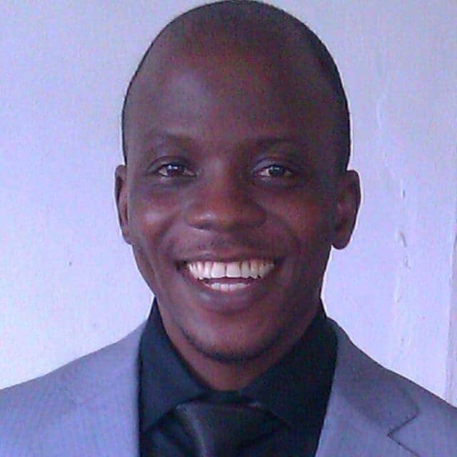 Professional tax advisor smiling in a suit for optimum tax services.