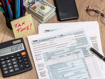 Tax documents and calculator for 2024 tax preparation.