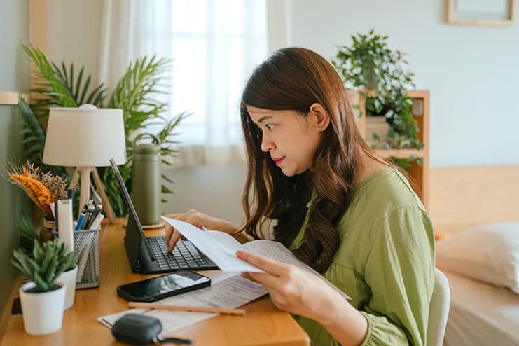 Woman reviewing tax documents at home for optimal tax season preparation.