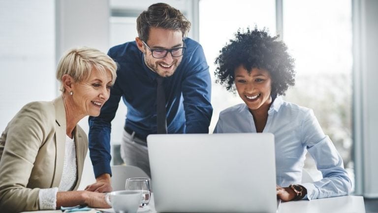 Business team collaborating on tax strategies at a laptop.